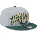 shapka-ploska-siv-snapbek-9fifty-tip-off-2023-na-milwaukee-bucks-nba-ot-new-era